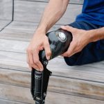 An adult adjusting their prosthetic leg outdoors, highlighting body positivity and disability representation.