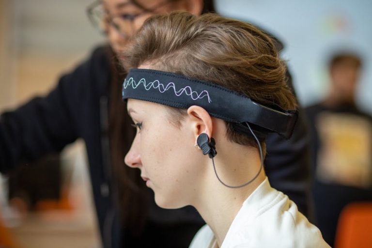 Close-up of a young woman wearing an EEG headband, showcasing modern technology indoors.