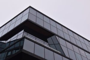 A striking modern building in Amsterdam with a reflective glass facade showcasing sleek architectural design.