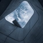 Architecting Cloud-Native SMPC for Mathematical Privacy Low angle view of modern architecture framing a beautiful cloudy sky.