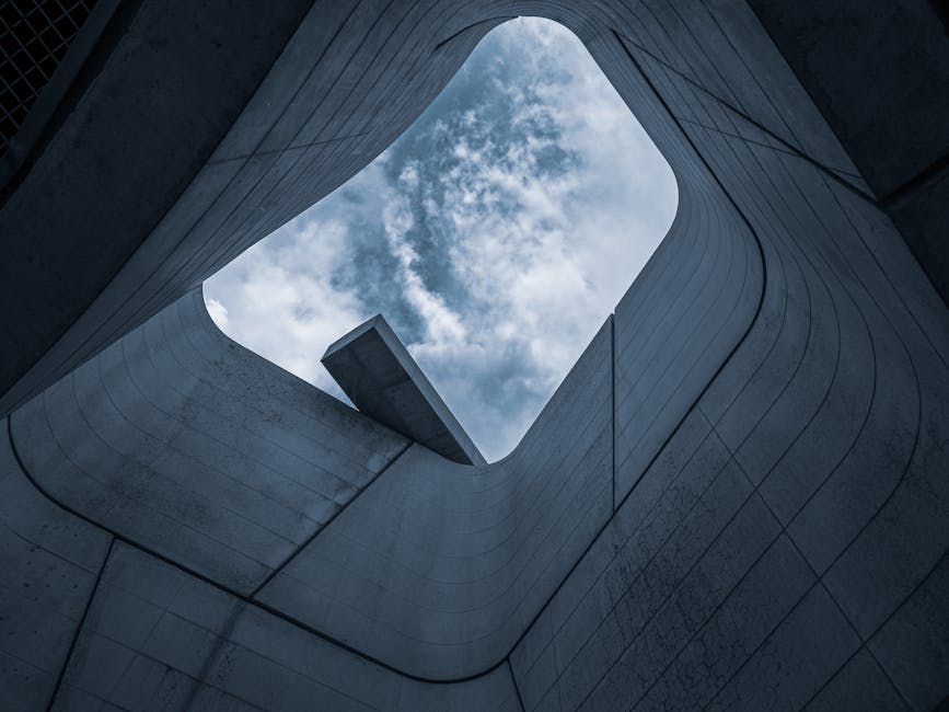 Low angle view of modern architecture framing a beautiful cloudy sky.