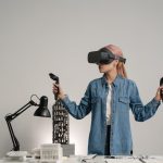 Young woman using virtual reality for architectural design in a modern office setting.