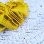 Architecting Fault-Tolerant Geospatial Intelligence Systems Stack of yellow QR code markers placed on a detailed map for location tracking and navigation.