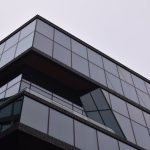 Architecting Interpretable Embodied Intelligence for AI Media A striking modern building in Amsterdam with a reflective glass facade showcasing sleek architectural design.