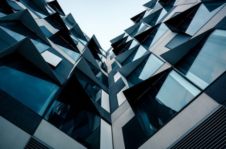 A low-angle view of futuristic modern architecture featuring unique geometric patterns and glass facade.