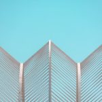 Contemporary geometric architectural structure set against a clear blue sky in Valencia.