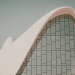 Architectural Ethics: How Built Environments Shape Leadership Decisions Futuristic curved building with modern glass design, showcasing innovative architectural elements.