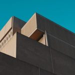 Architectural Narrative: Building Strategy Through Literary History A striking view of a modern concrete structure against a vibrant blue sky in London, Ontario.