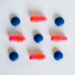 Autonomous Bioelectronic Medicine: Standards for Complex Systems Various blue and pink pills and capsules arranged on a white background, showcasing medication.