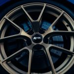 Detailed view of Apex alloy car wheel rim and tire, showcasing design and texture.