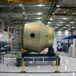 Heavy detail of spacecraft placed on rolling platform under construction at futuristic rocket factory