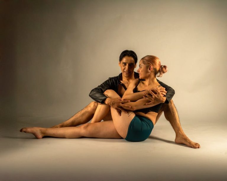Artistic portrait of a contemporary dance duo posing intimately in a studio.