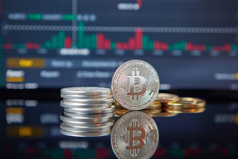 Stack of Bitcoin coins in front of a stock market graph, reflecting cryptocurrency trends.