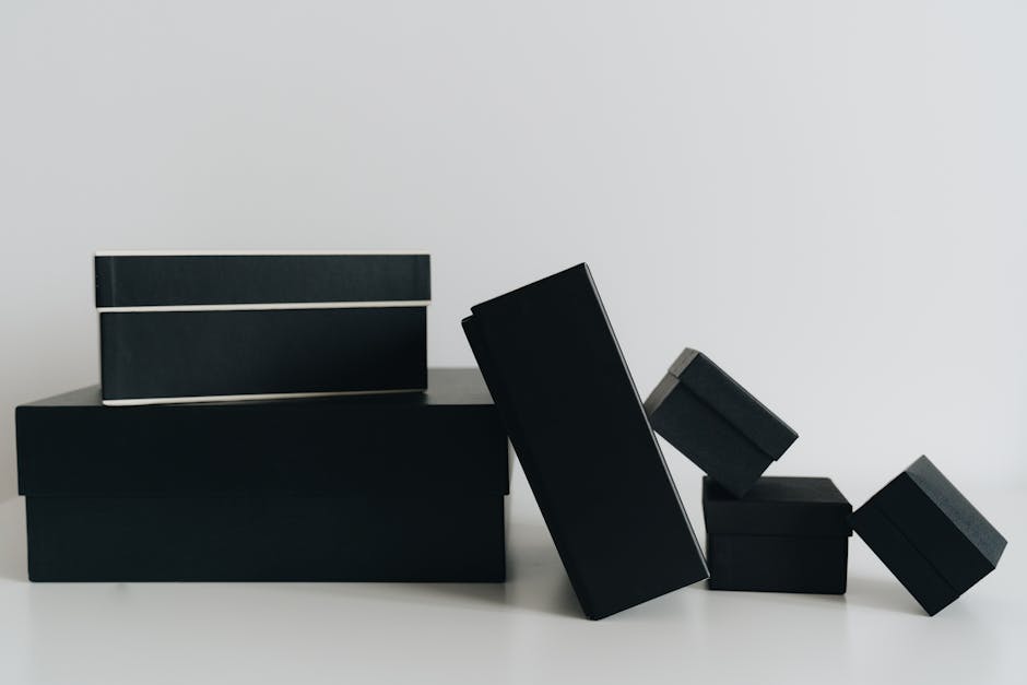 A minimalist display of black gift boxes of varying sizes against a white background.