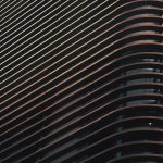 <h1>Building a Continual-Learning Architecture for Synthetic Media</h1> Abstract close-up of a modern building facade featuring a series of curved lines and shadows.