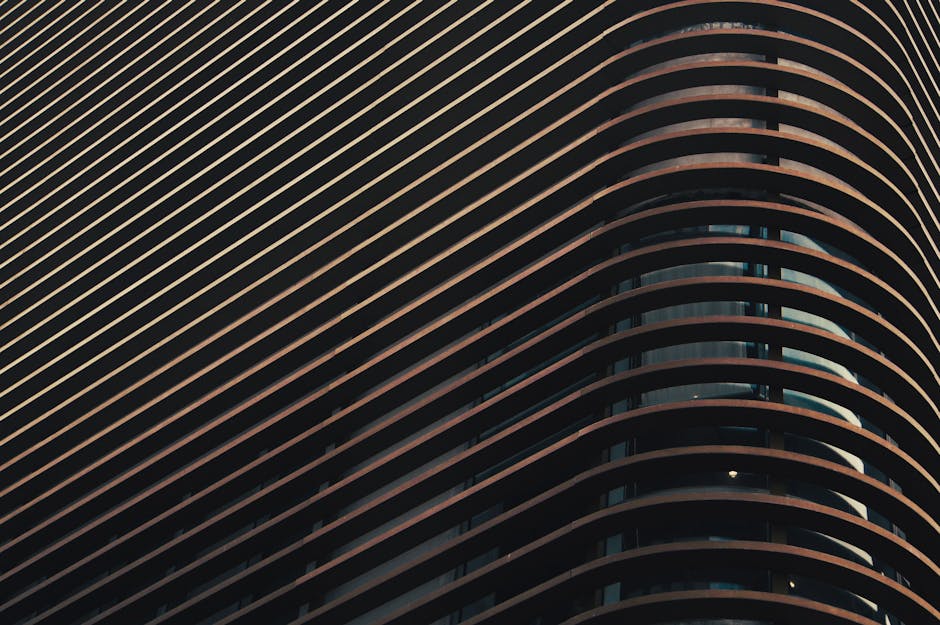 Abstract close-up of a modern building facade featuring a series of curved lines and shadows.