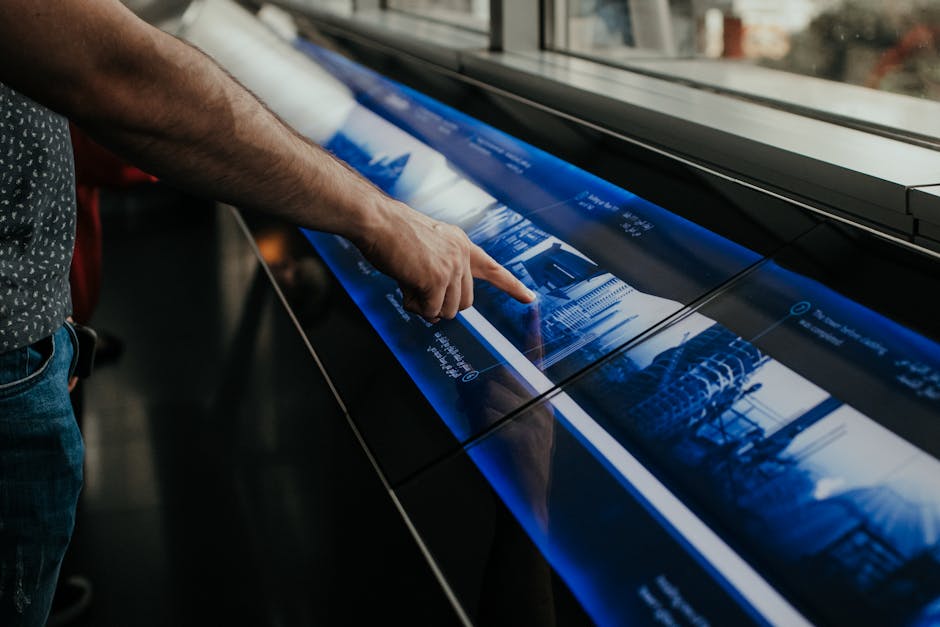 Close-up of a person interacting with a touchscreen display in a modern environment.