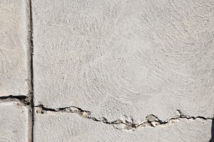 Close-up view of a cracked concrete surface with distinct textures in Logan, Utah.