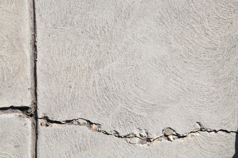 Close-up view of a cracked concrete surface with distinct textures in Logan, Utah.