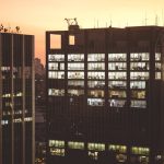 <h1>Building Resilience: The Robust-to-Distribution-Shift Hospital-at-Home Compiler for Supply Chain</h1> City office buildings illuminated against a sunset backdrop, showcasing urban life.