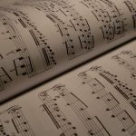 Category Theory for Open-World XR Control Policies: A Guide Detailed view of an open music book displaying musical notes and sheet music.