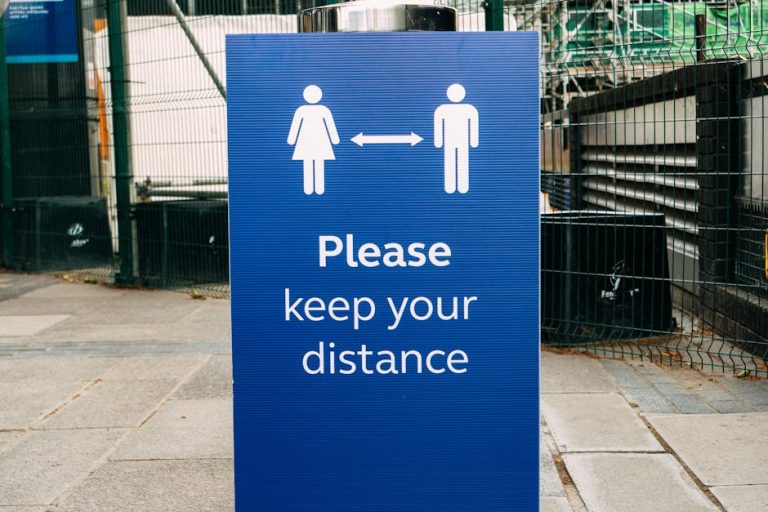 Banner with inscription Please Keep Your Distance and arrow between human figures on street during coronavirus epidemic