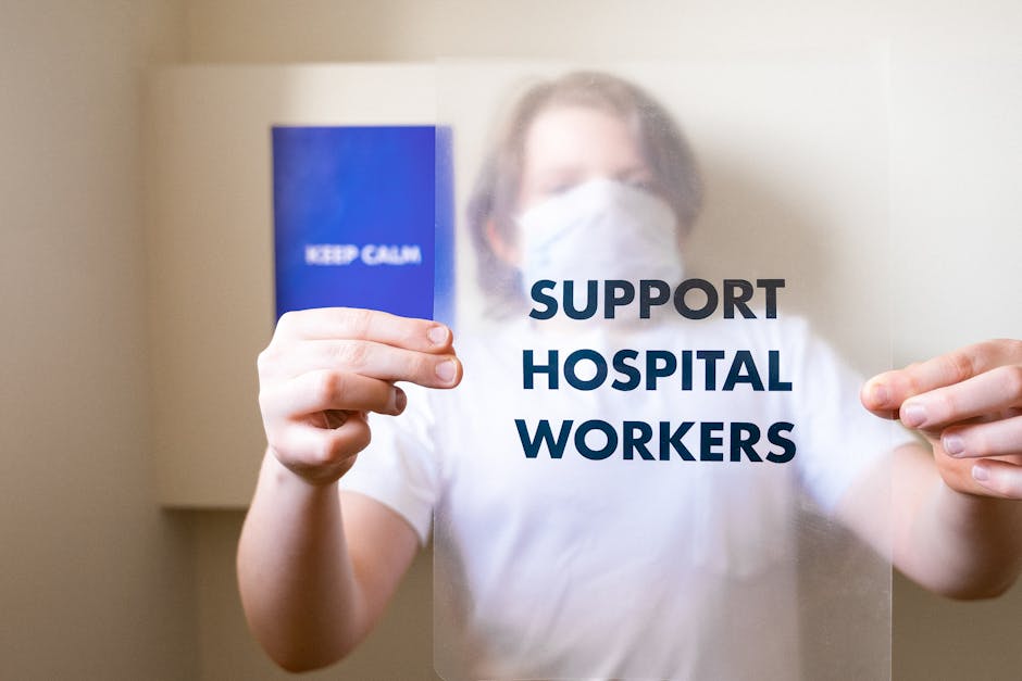 Person holding a support hospital workers sign, promoting health care and pandemic awareness.