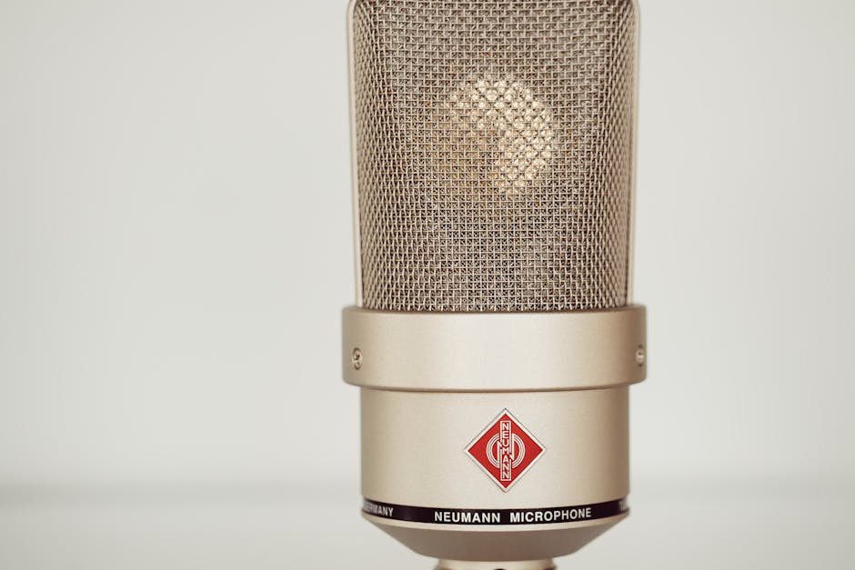 Close-up image of a vintage Neumann condenser microphone showcasing its metallic design.