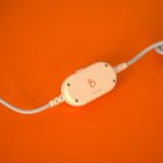 Headphone accessory on an orange background, showcasing sleek design.
