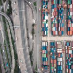 Aerial shot of Hong Kong's shipping containers and highway interchange showcasing urban logistics.