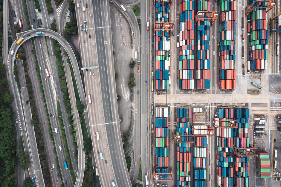 Aerial shot of Hong Kong's shipping containers and highway interchange showcasing urban logistics.