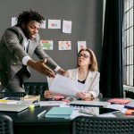 Conflict as a Creative Catalyst: Insights for Strategic Leadership Colleagues in a lively discussion during a team meeting in a modern office space.
