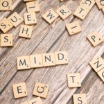 Scattered wooden letter tiles on a rustic wood surface highlighting the word 'Mind'. Ideal for mental and cognitive themes.