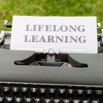 Continual Learning Edge Orchestration for AI Media Close-up of a typewriter typing 'Lifelong Learning' outdoors, symbolizing continuous knowledge growth.