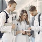 Continual Learning in Healthcare: Building Adaptive Medical AI Three medical students in a hallway discussing notes, fostering teamwork and learning.