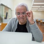 Continual-Learning Metamaterials for Space Resilience Elderly man using a laptop in a classroom setting, learning new technology skills.