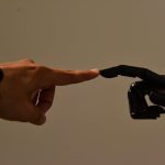 Cooperative Embodied Intelligence: The Future of EdTech A human hand and a robotic hand extending fingers to touch, symbolizing connection.
