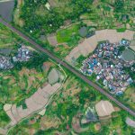 Stunning aerial photo of a rural Chinese village with lush green rice fields and irrigation ponds.