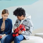 Cooperative Learning in Robotics: A Guide to Human-Robot Teams Two teenagers sitting and collaborating on a robotics project in a casual indoor setting.