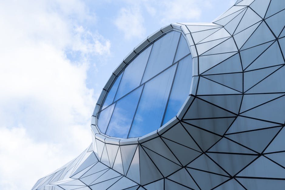 Modern, geometric architectural structure with a unique window design under a bright blue sky.
