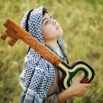 Cultural Identity and the Future: Strategy for Global Leaders A thoughtful Palestinian child holds a symbolic key, representing heritage and hope, in an outdoor setting.