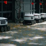 <h1>Decentralized Autonomous Logistics: The Future of Vehicle Toolchains</h1> Autonomous delivery robots lined up outdoors showcasing modern transportation technology innovations.