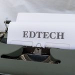 A vintage typewriter with a paper labeled 'EDTECH', signifying educational technology.