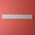 Close-up of letter tiles spelling PRIVACY on a red background, symbolizing data protection.