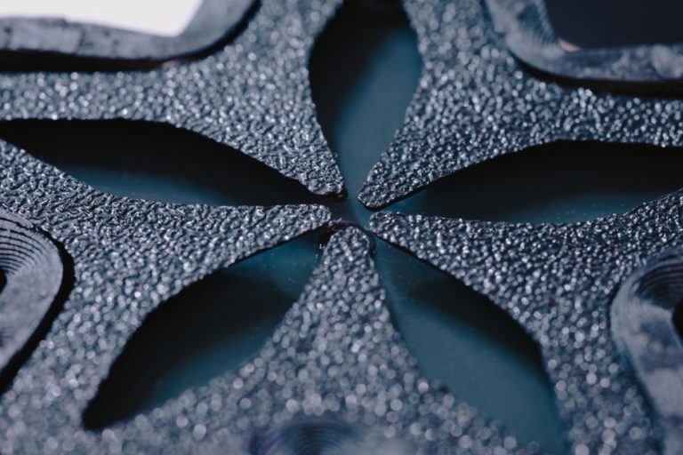 High-detail macro shot of black textured abstract shapes forming a unique geometric pattern.