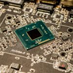 <h1>Edge-Native Neuromorphic Chips: The Future of Distributed Artificial Intelligence</h1> Detailed view of a microchip on a printed circuit board, showcasing electronic components.