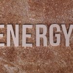 Word 'Energy' on natural stone texture, symbolizing raw power.