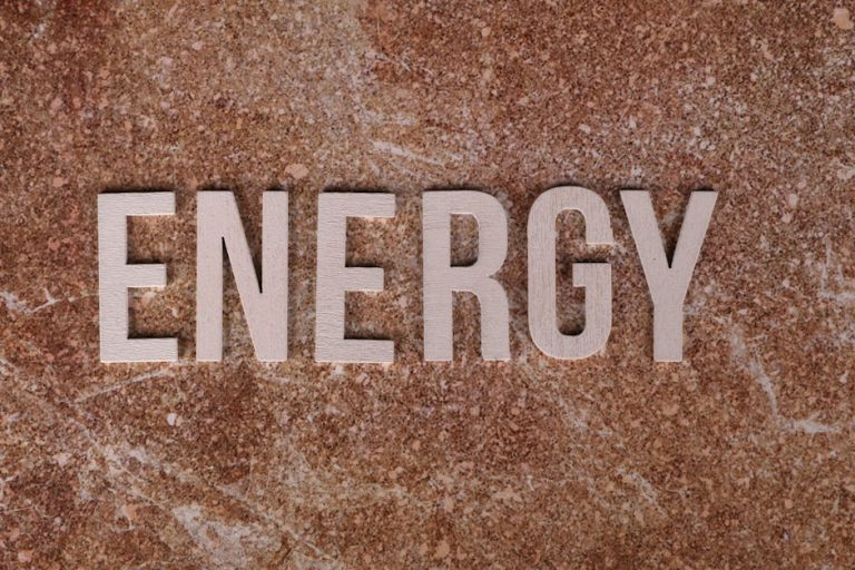 Word 'Energy' on natural stone texture, symbolizing raw power.