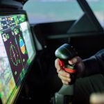 Energy-Aware ISRU Simulators: Scaling Climate Tech Effectively Close-up of a simulated aircraft cockpit with control joystick and digital display.