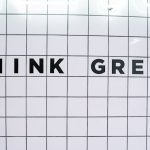 Modern wall art featuring the inspiring text 'Think Green' on a tiled background.